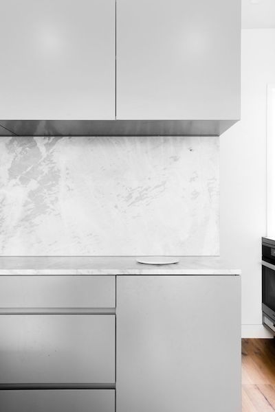 cocina-gris-marmol-blanco-neutro-banco-pared-mundo-petreo