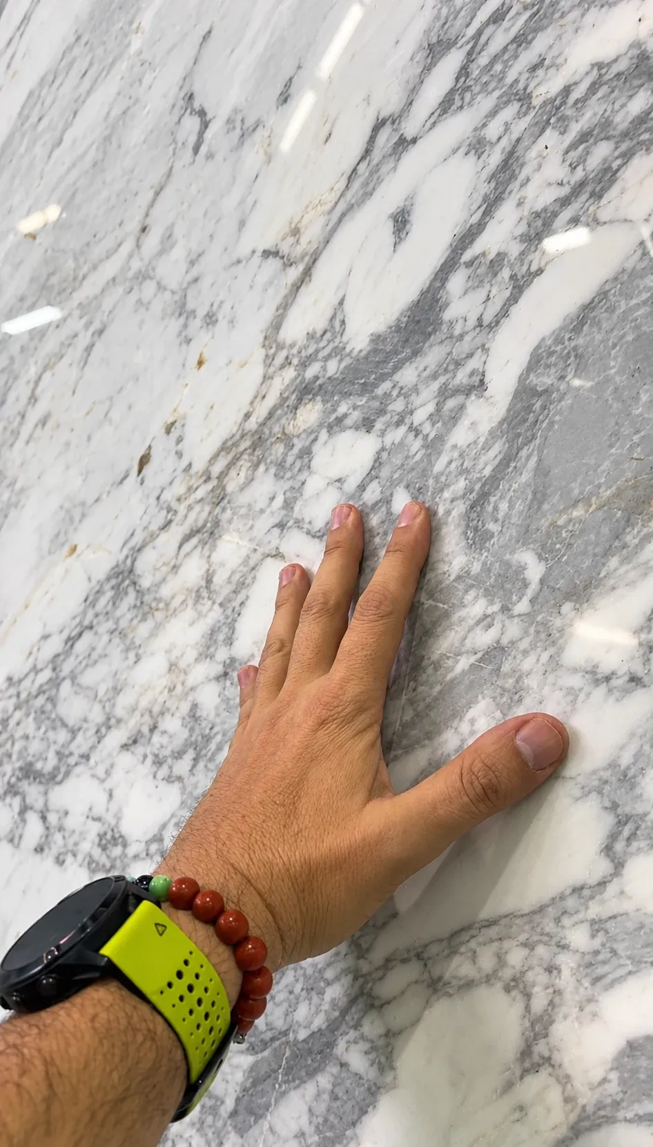 Una mano recorre la superficie y las vetas de una tabla de mármol