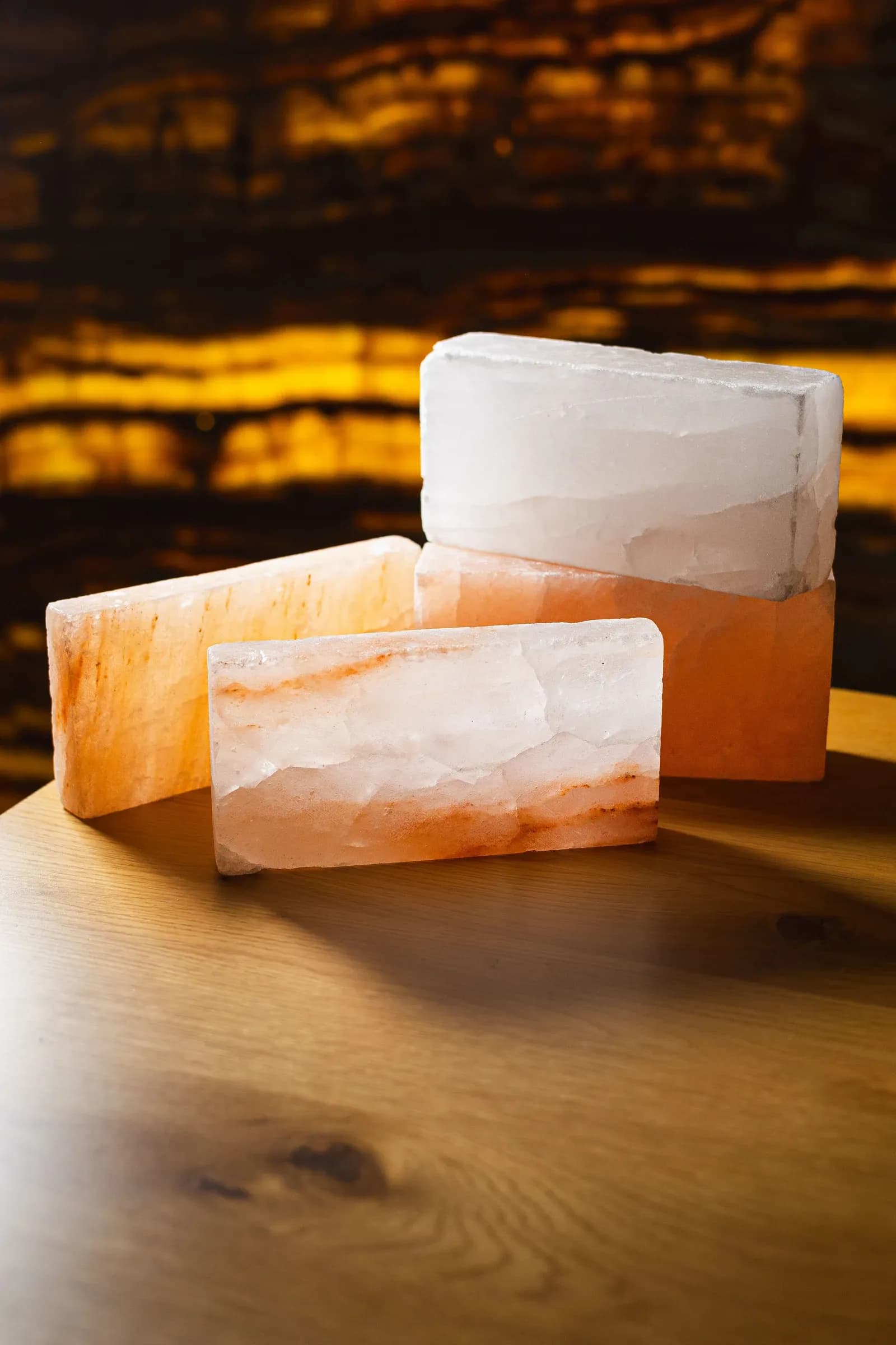Piezas de Piedra del Himalaya Nácar y Coral sobre una mesa, con iluminación cálida al fondo